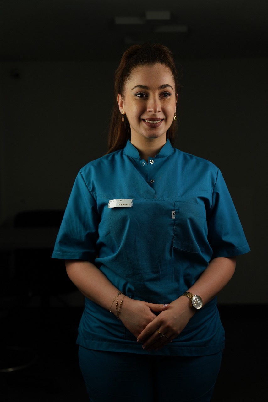 Team member in teal scrubs, name tag reading Myriam